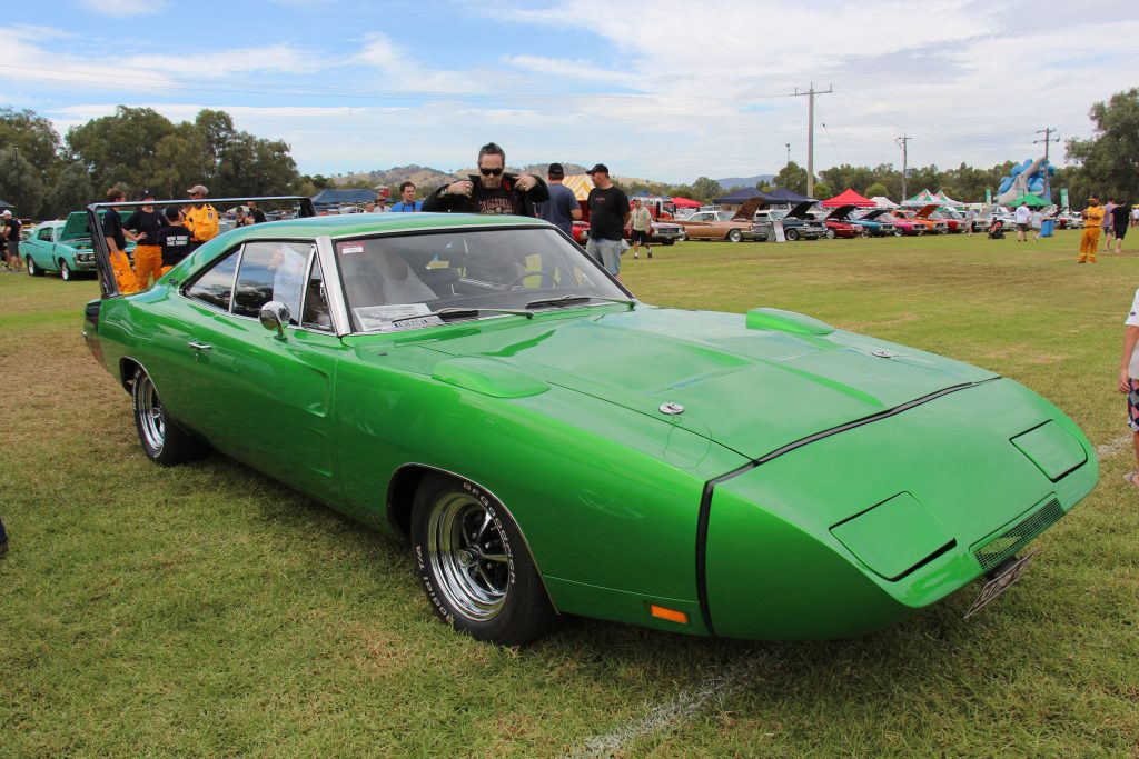 1969 Dodge Charger Daytona in bright green with aerodynamic nose cone and rear wing at a classic car show