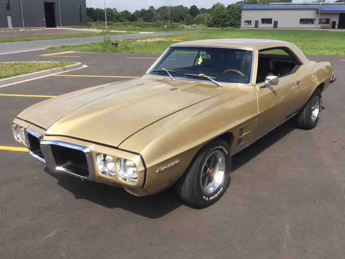 Classic 1969 Pontiac Firebird in gold color at a car show