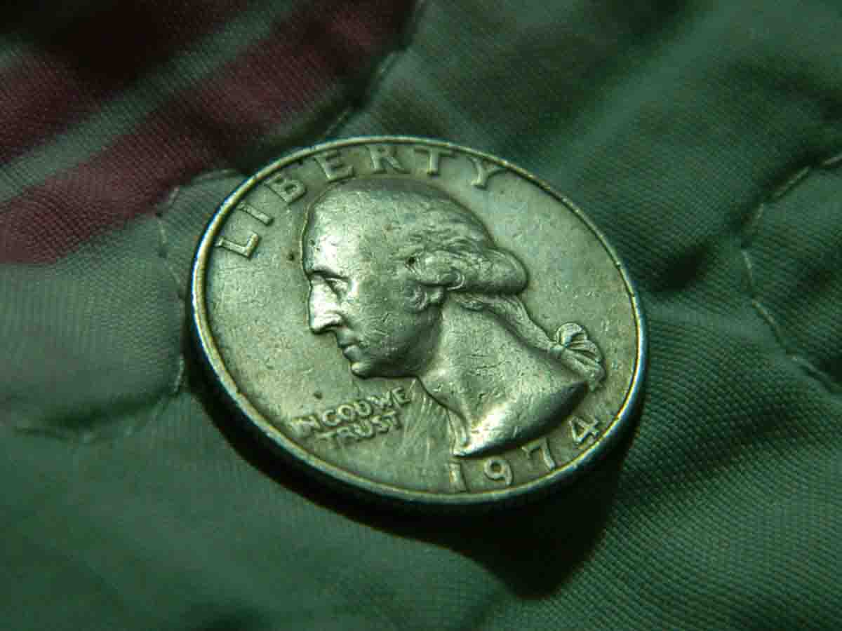 A close-up of a 1974 U.S. quarter on a textured surface