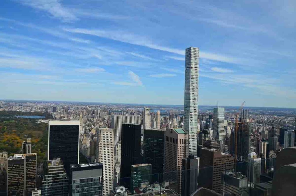 A once-majestic skyscraper abandoned and decaying in an urban setting.